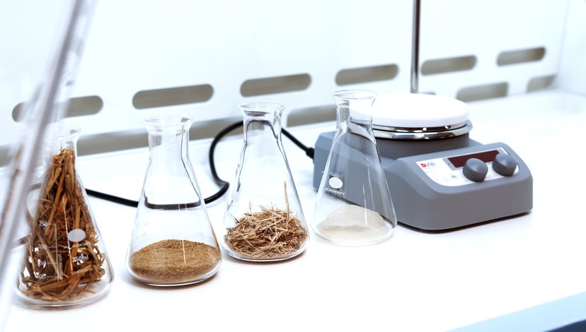 A close up of material samples in flasks and a set of scales.