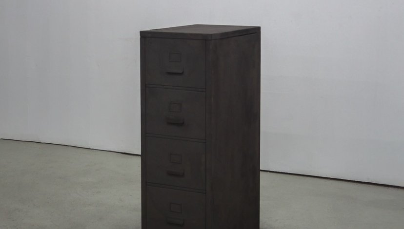 A dark filing cabinet in a grey room