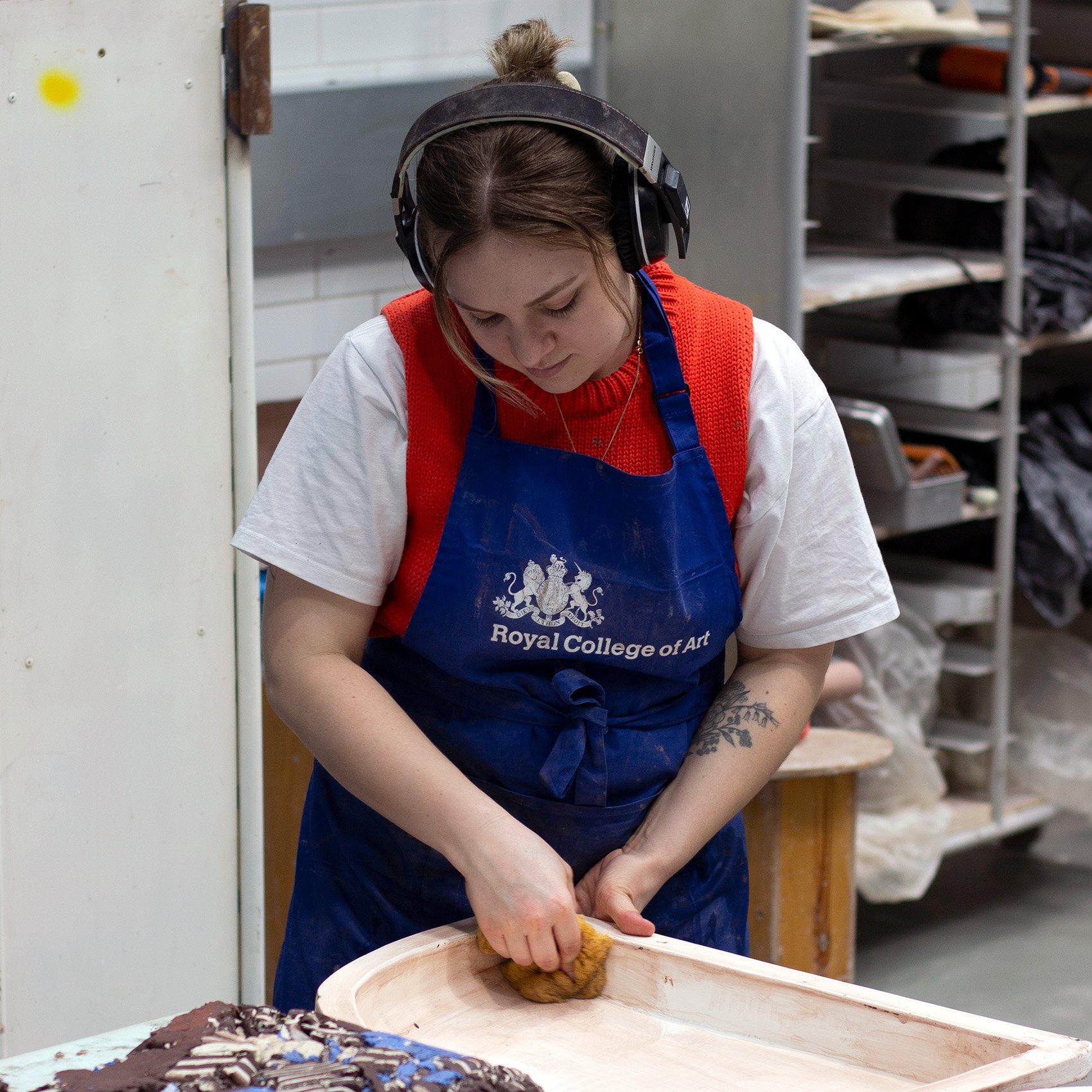 Serena Dicks in the workshop wearing headphones