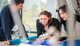 Three students collaboraring on a project